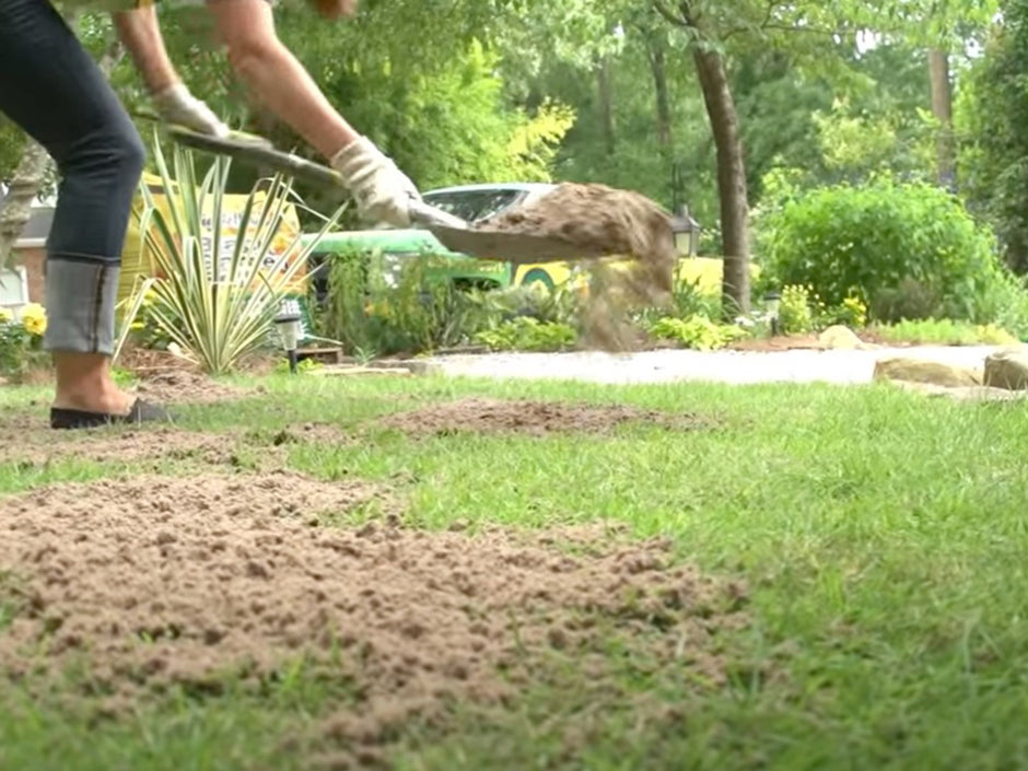 spreading level mix with a shovel on a lawn